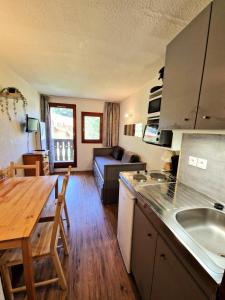 a kitchen and living room with a table and a couch at Chalet Club - Studio 17m² 2/3 persons pied piste MAE-2980 in Modane