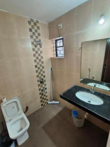 a bathroom with a toilet and a sink and a mirror at SHANKAR by the SEA, 2 min from Mandrem Beach in Mandrem
