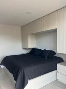 a bedroom with a large black bed with wooden cabinets at Departamento B céntrico y moderno in Zacatecas