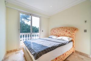 una camera da letto con un letto e una grande finestra di Logement entier villa de luxe avec vue mer a Théoule-sur-Mer Altre 37 foto