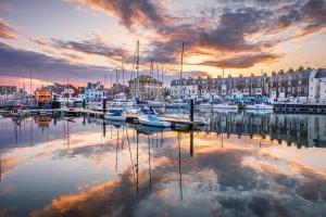 a group of boats docked in a marina at sunset at Sea breeze holiday apartment in Weymouth