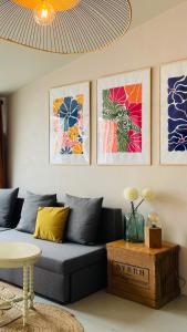 a living room with a couch and some pictures on the wall at Petite maison en bord de mer in Longeville-sur-Mer