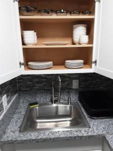 a kitchen sink with plates and dishes in a cabinet at AWESOME PLACe in Las Vegas +21 photos