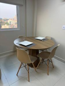 a wooden table and chairs in a room with a window at Apartamento 122 - Luxo in Ribeirão Preto +5 photos