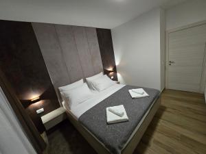 奥西耶克Apartman FIŠBAH 6 self CHECK-IN, FREE PRIVATE PARKING的一间卧室配有一张带两张餐巾的床