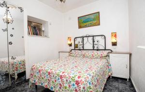 a bedroom with a bed with a floral bedspread at 2 Bedroom Cozy Apartment In Vidreres in Vidreres +14 photos