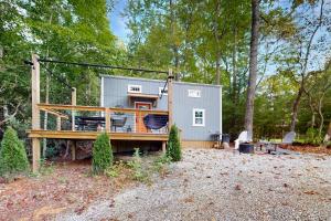 una casetta nel bosco con un ponte di Cozy Lakeview Cottage a Mills River
