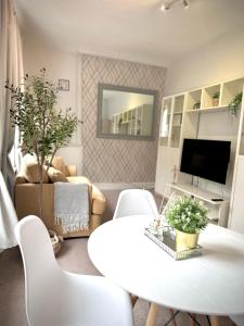 a living room with a white table and chairs at London Oval Apartment in London
