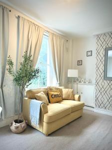 a living room with a couch in front of a window at London Oval Apartment in London