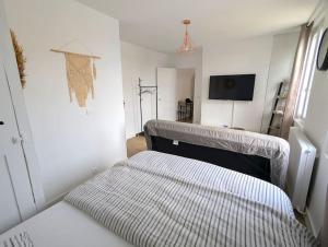 Un dormitorio con una cama y un televisor. en maison, en Martot