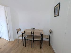 Un comedor con mesa y sillas de madera. en maison, en Martot