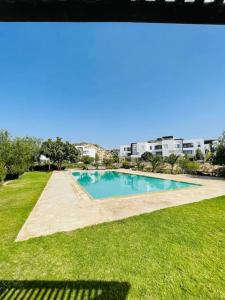 una piscina in mezzo a un prato di Ocean and Sunset View Appartement Taghazout bay a Tamraght Ouzdar