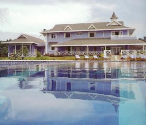 a large house with a swimming pool in front of it at Villa Ananda Tobago in Patience Hill
