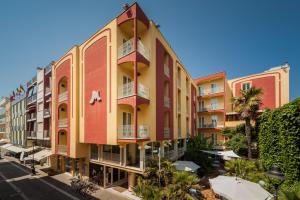 a building with pink and yellow at Hotel Resort Marinella in Gabicce Mare