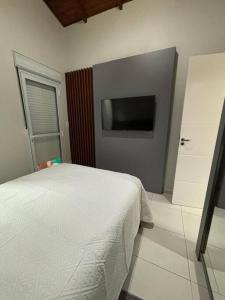 帕罗卡Casa Ocean Pé na areia的一间卧室，里面有一张床和一台平板电视
