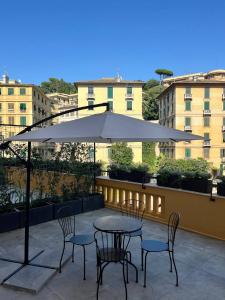 ein Tisch und Stühle mit einem Sonnenschirm auf einer Terrasse in der Unterkunft B&B Dimora Liberty in Genua + 27 Fotos