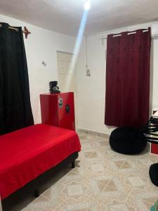 ein Zimmer mit einem roten Bett und einem roten Vorhang in der Unterkunft Casahuitron in Mahahual