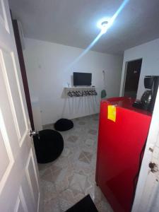Zimmer mit einem roten Kühlschrank und einem TV. in der Unterkunft Casahuitron in Mahahual