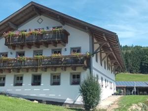 a building with a balcony with flowers on it at Ferienwohnung im Bayerischen Wald mit Terrasse in Viechtach
