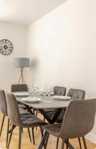 a dining room with a table with chairs and a clock at Spacious Two Bedroom Apartment in Battersea, Free Parking in London