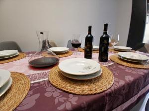 a table with plates and wine bottles and glasses at Casa Puente Rioja in Cenicero