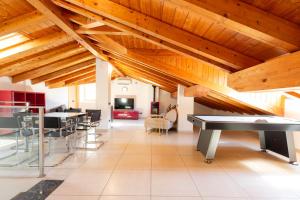ラーリオにあるLuxury Apartments with share Poolの卓球台と椅子が備わる広い客室です。