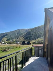 Russa Kottages في Ach'khoti: شرفة منزل مع جبال في الخلفية
