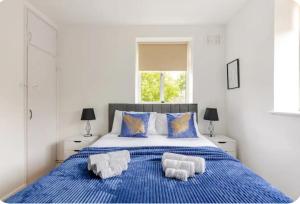 a bedroom with a blue bed with towels on it at Spacious Two Bedroom Apartment in Battersea, Free Parking in London