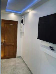 Una habitación con un televisor de pantalla plana en una pared. en Petit nid sympa a Strasbourg, en Estrasburgo