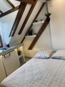 1 dormitorio con cama blanca y techo de madera en Petit nid sympa a Strasbourg, en Estrasburgo
