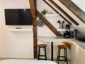a room with two stools and a tv on a wall at Petit nid sympa a Strasbourg in Strasbourg