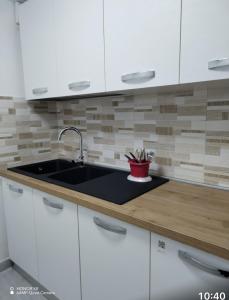 a kitchen with white cabinets and a sink at La taverna del mare in Civitavecchia +17 photos