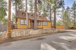 a yellow house with a stone wall and trees at The Twin Pines Chalet, 2 min to Village, BBQ in Big Bear Lake