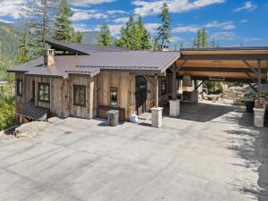 a house with a large patio in front of it at Snowghost Chalet Ultimate Luxury Ski In Ski Out 5BD 55BA with Hot Tubs Steam Room and Game Room in Whitefish