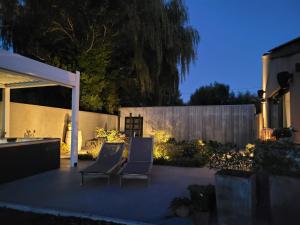 two chairs sitting on a patio at night at Hedone - Overnachting met wellness in Heuvelland