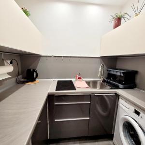une petite cuisine avec une cuisinière et un évier dans l'établissement Apartament Centrum Warszawa, à Varsovie 12 autres photos