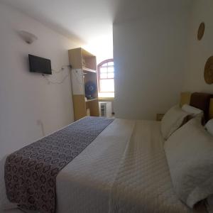 a bedroom with a large bed and a window at Casa Hospedagem Diamantina in Diamantina