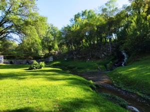 un prato con un fiume al centro di El Aromito ad Alta Gracia