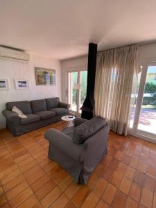 a living room with a couch and a chair at Xalet Argany in Sant Jordi d'Alfama in Les tres Cales +16 photos