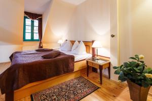 カルロヴィ・ヴァリにあるホテル マルテズスキー クリーシュのベッドルーム1室(ベッド1台、植物のあるテーブル付)