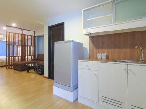 a kitchen with a refrigerator and a living room at Huahin City View in Hua Hin