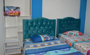 1 dormitorio con 2 camas y cabecero verde en Apartamento turístico portal del prado, en Santa Rosa de Cabal