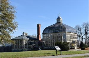 een grote kas in een park met een bord in het gras bij Home Away From Home in Baltimore