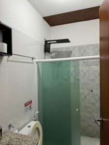 a bathroom with a toilet and a glass shower stall at Vivendas do Serrano Apart105 Lençois in Lençóis +13 photos