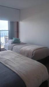 three beds in a room with a window at Gran Parador SKI In SKI Out El Colorado Chile in El Colorado