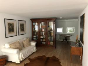 a living room with a white couch and a table at Ganzes Haus in ruhiger Lage zwischen Heidelberg und Mannheim in Edingen-Neckarhausen +6 photos