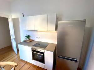a kitchen with white cabinets and a stainless steel refrigerator at Apartment im Herzen Hamburgs in Hamburg +12 photos