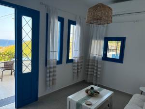 a living room with a blue door and windows at Mochlos Thea Thalatta in Mochlos