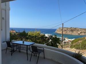 a table and chairs on a balcony with a view of the ocean at Mochlos Thea Thalatta in Mochlos
