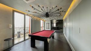 a pool table in a room with a large chandelier at 360 VN Turiassú by Housi in Sao Paulo